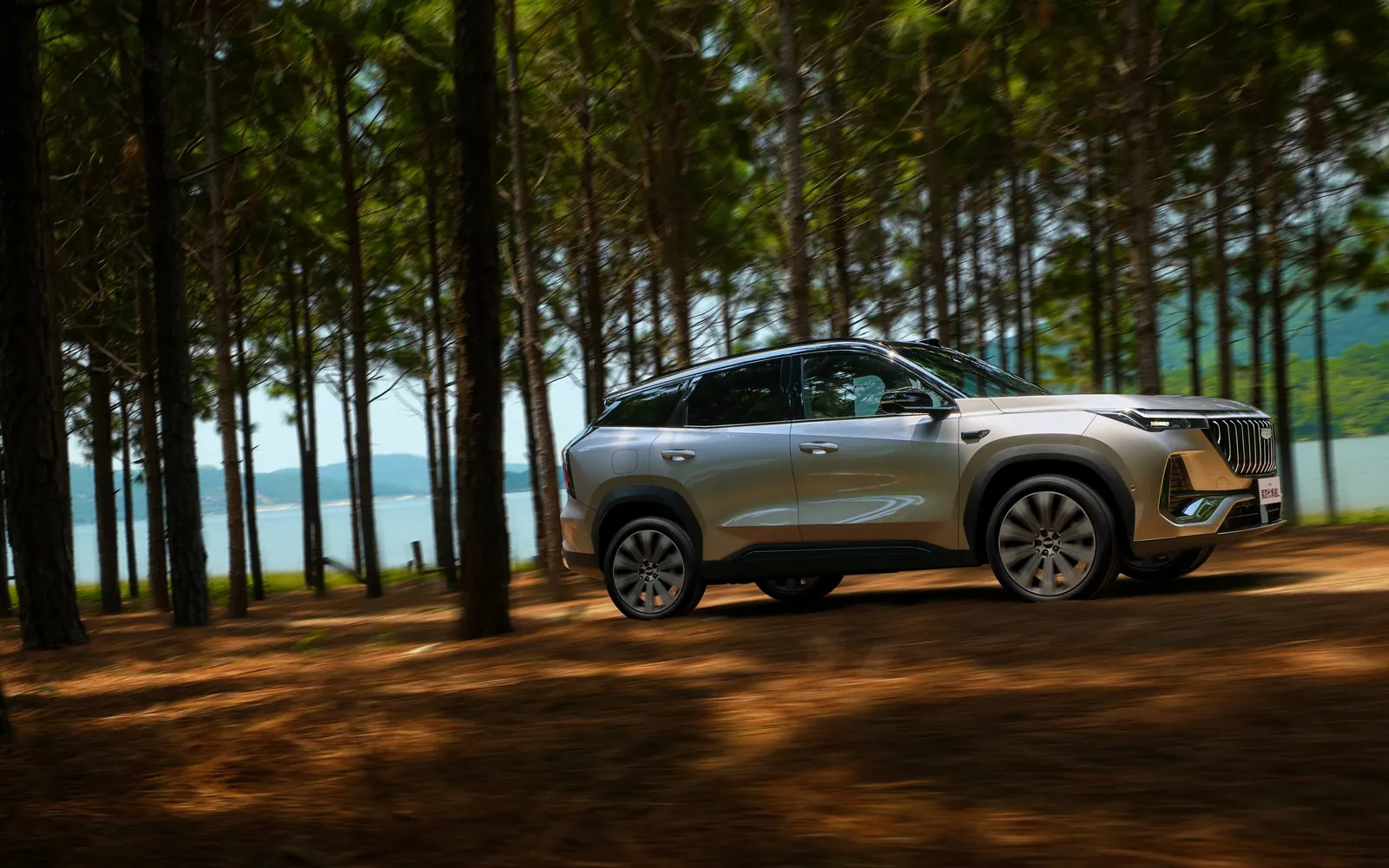 Geely Boyue L – вид спереди сбоку в лесу